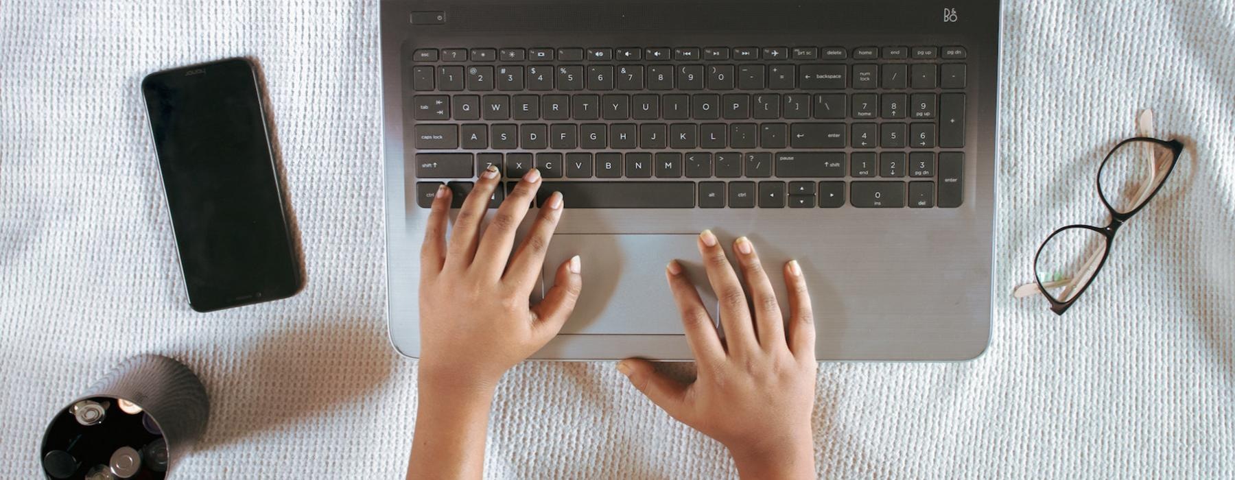 a person's hands on a laptop